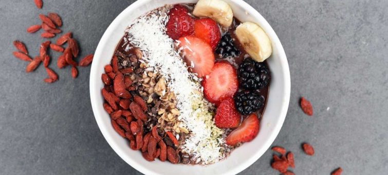 zdravá snídaně v podobě jogurtu s jahody, banáném a ostružinami