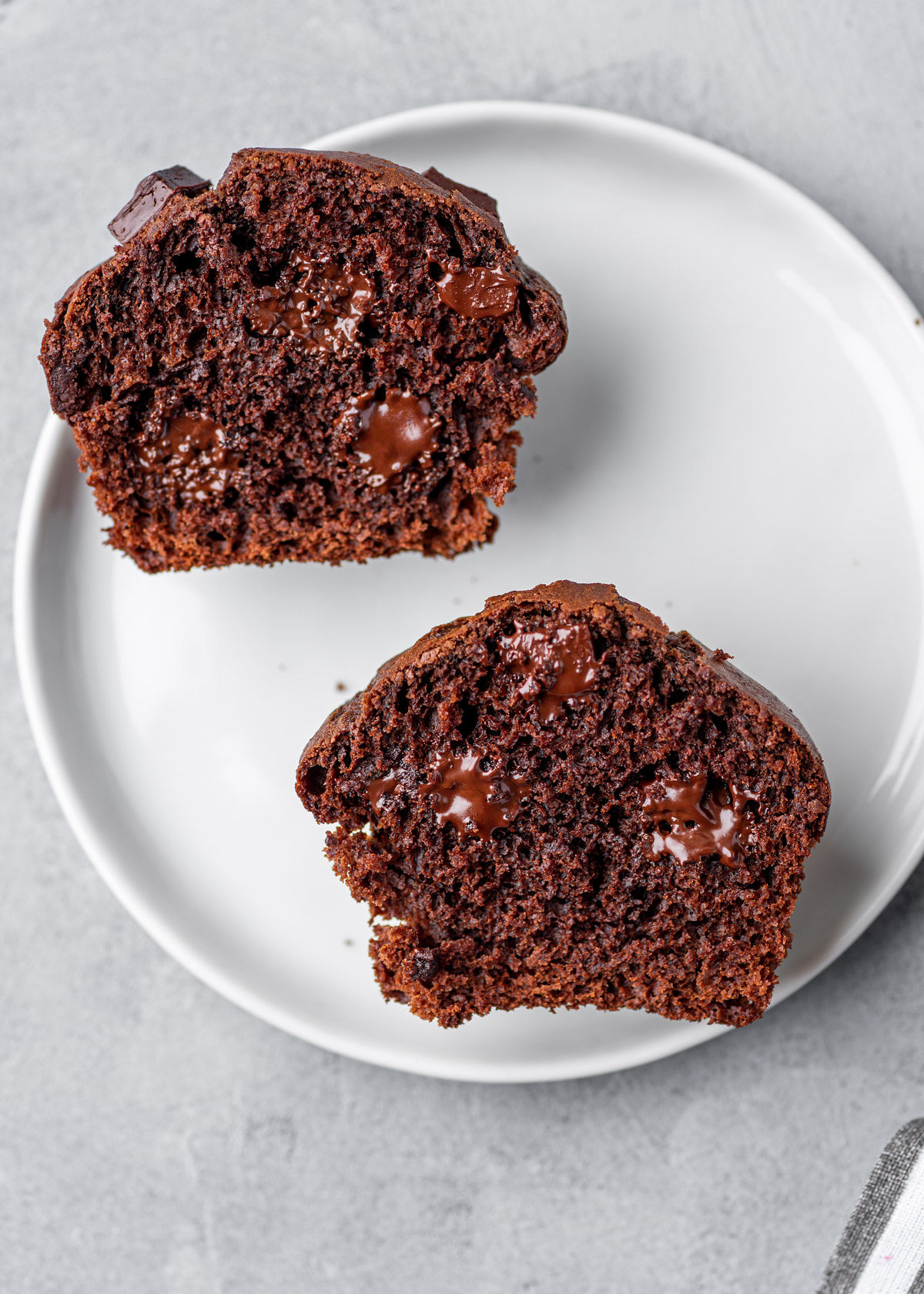 Rozkrojený čokoládový muffin na bílém talíři