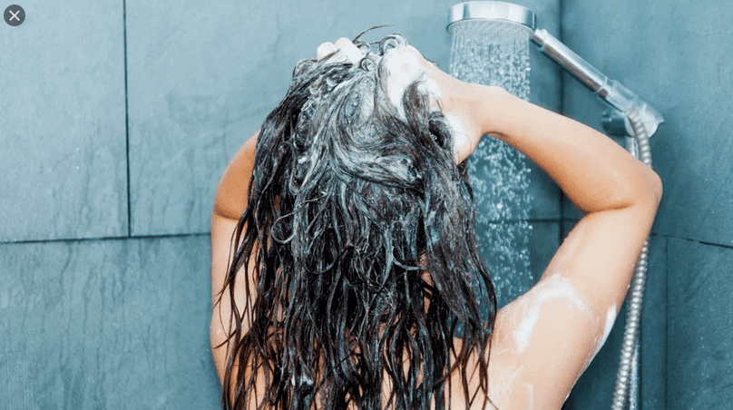 žena myje vlasy šampónem